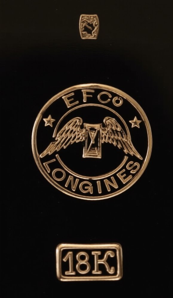 Inside a Longines gold case back: EFCO winged hourglass cartouche and 18K stamp