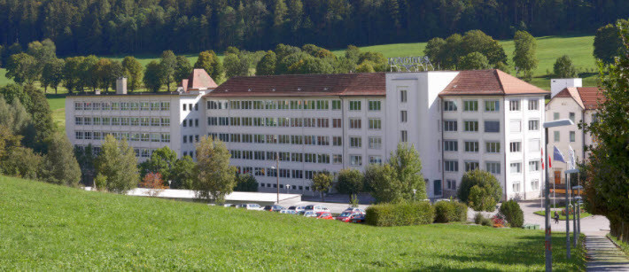 The Longines factory at Saint-Imier in the Swiss Jura, seen across open meadow