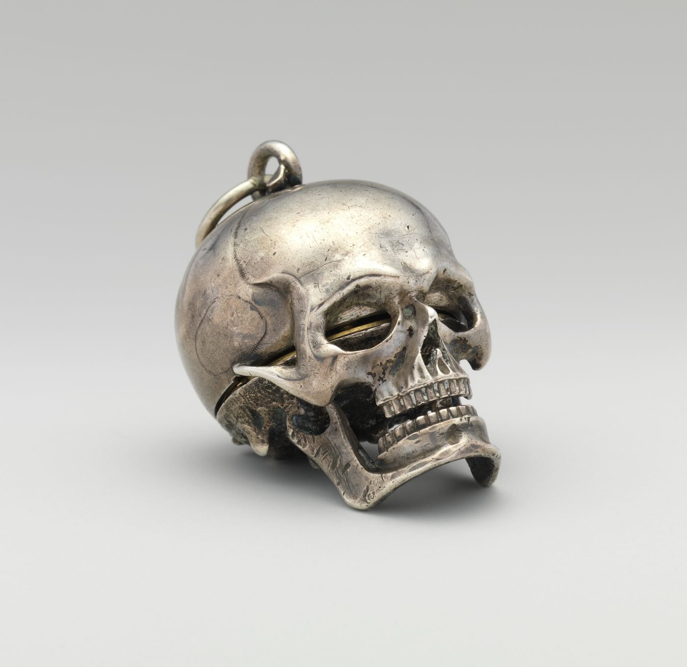 Silver skull watch, jaw closed, gilt movement showing through the eye sockets